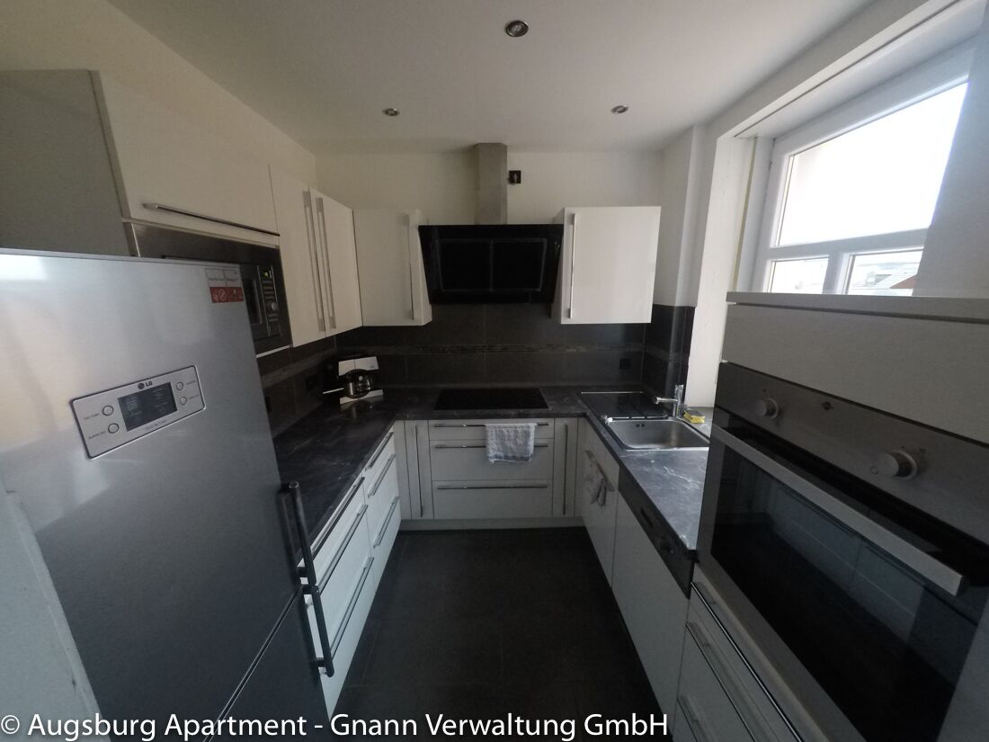 Einbauküche mit Kühlschrank, Backofen und Kochfeld in einer Ferienwohnung in Augsburg